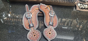 Buckle over bib style spur straps with serpentine pattern